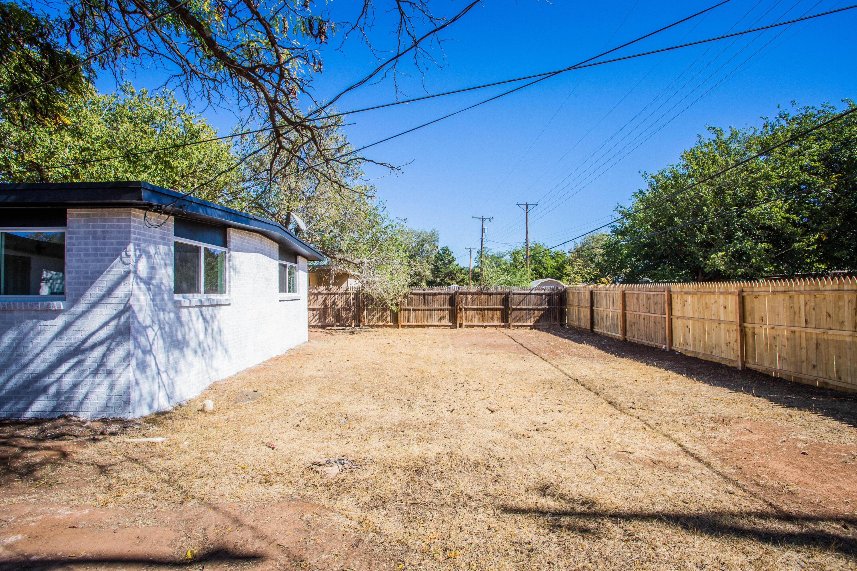 2725 63rd Street Lubbock, TX 79413 - Photo 35 of 41 a view of backyard with wooden fence and large trees