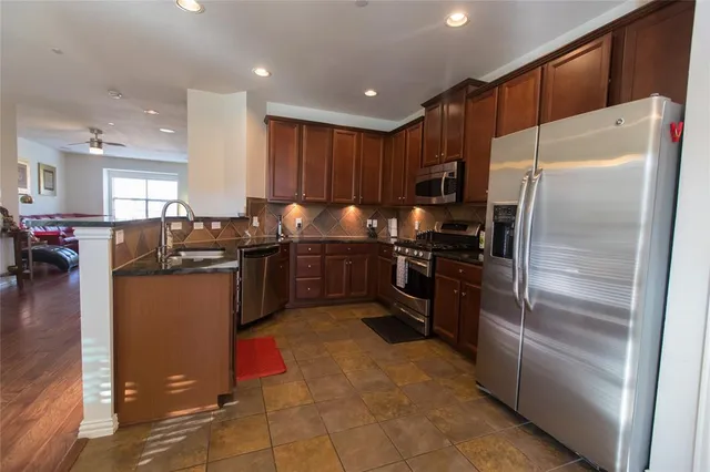 a kitchen with granite countertop stainless steel appliances and refrigerator