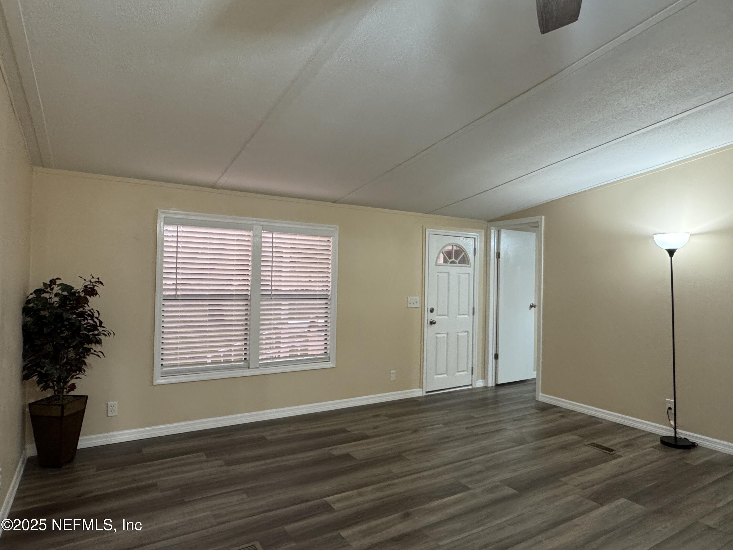 106 Ridgewood Avenue Interlachen, FL 32148 - Photo 20 of 23 a view of an empty room with a window and wooden floor