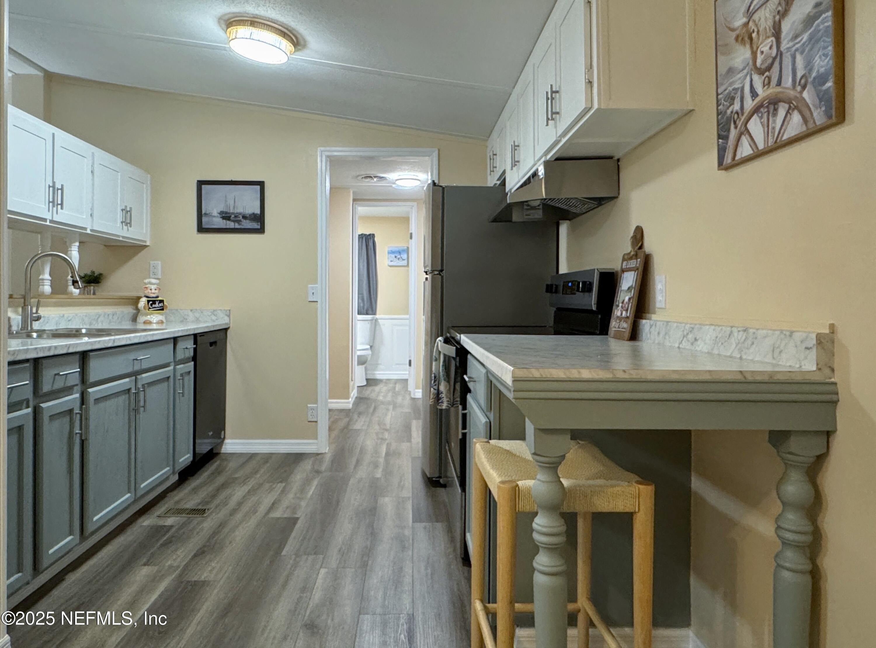 106 Ridgewood Avenue Interlachen, FL 32148 - Photo 2 of 23 a kitchen with a sink appliances and wooden floor