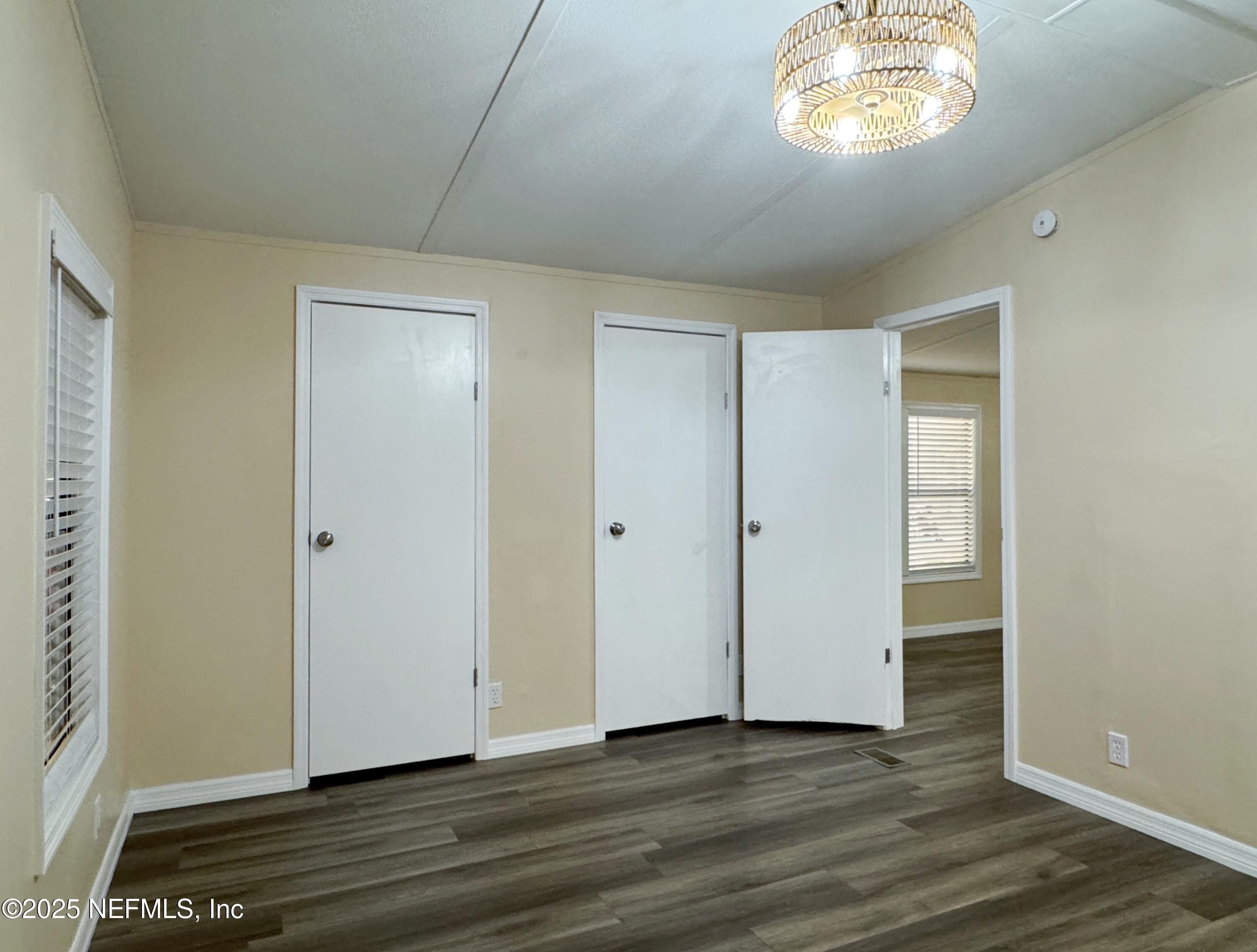 106 Ridgewood Avenue Interlachen, FL 32148 - Photo 23 of 23 a view of an empty room with wooden floor and a window
