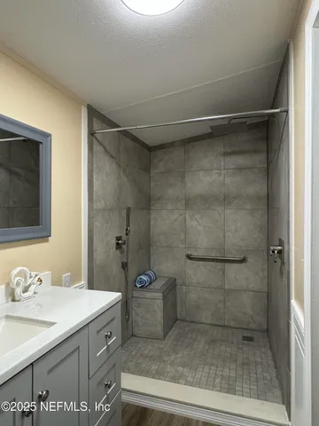 a bathroom with a granite countertop sink a toilet and shower