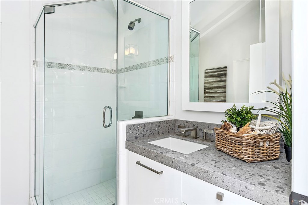 2526 Monaco Drive Laguna Beach, CA 92651 - Photo 30 of 59 a bathroom with a granite countertop sink a mirror a vanity and a shower