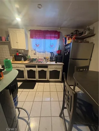 a kitchen with a stove a refrigerator and a dining table