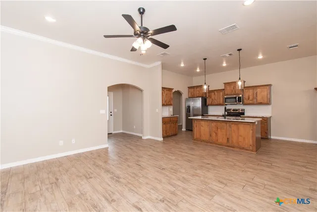a kitchen with stainless steel appliances kitchen island a refrigerator sink and stove