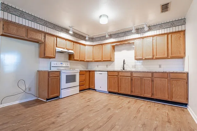 a kitchen with stainless steel appliances granite countertop a stove sink and cabinets