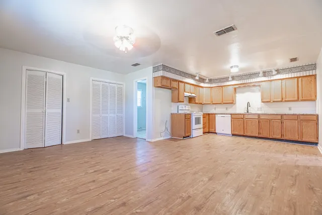 a view of a kitchen with wooden floor and windows
