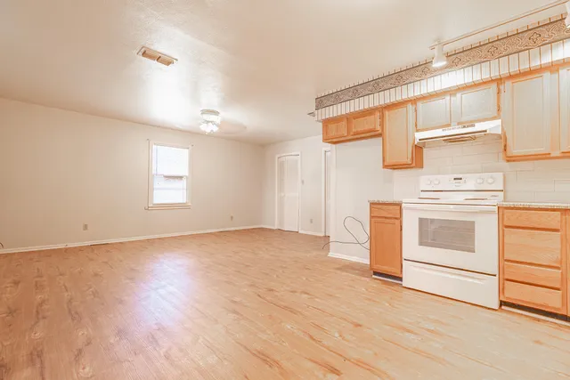 a view of a kitchen with wooden floor and electronic appliances