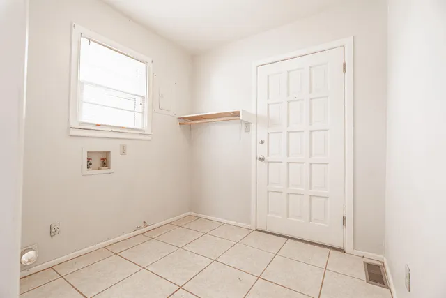 a view of an empty room with window and cabinet