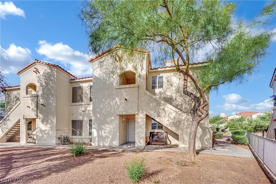 698 South Racetrack Road, Unit 1521 Henderson, NV 89015 - Photo 2 of 33 A cream-toned stucco exterior with red tile roofing exudes Southwestern charm, surrounded by xeriscaped grounds.