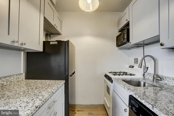 a kitchen with stainless steel appliances granite countertop a sink and a stove