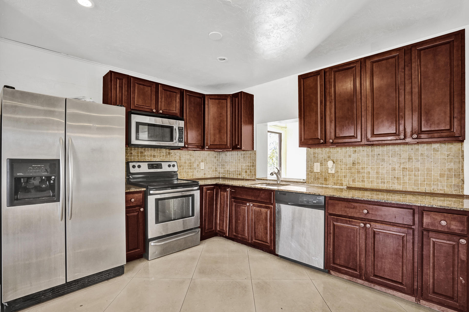a kitchen with stainless steel appliances granite countertop a stove top oven a sink and dishwasher