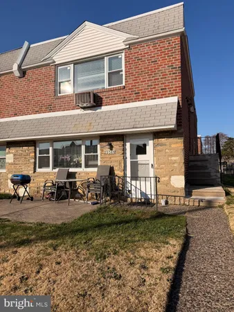 a front view of a house with lots of garden and patio