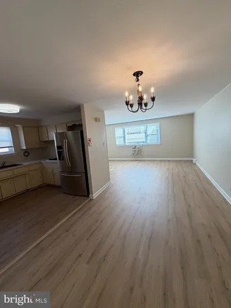 a view of a livingroom with wooden floor a ceiling fan and a window