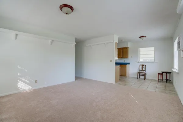 a view of an empty room with window and a flat screen tv
