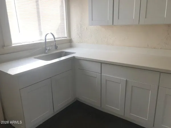 a kitchen with white cabinets and black appliances