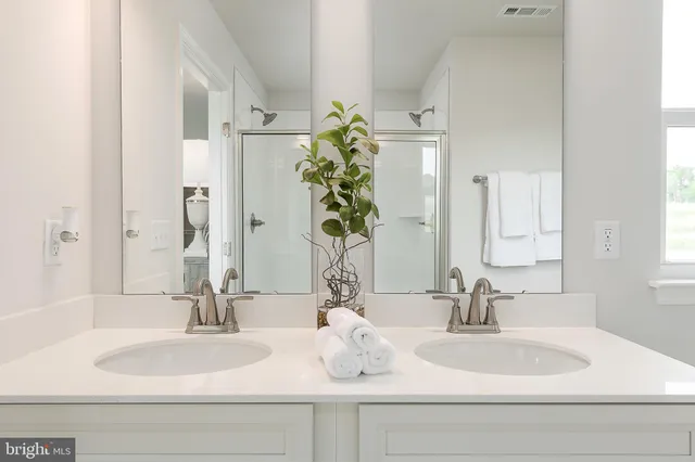 a bathroom with double vanity sinks and a mirror