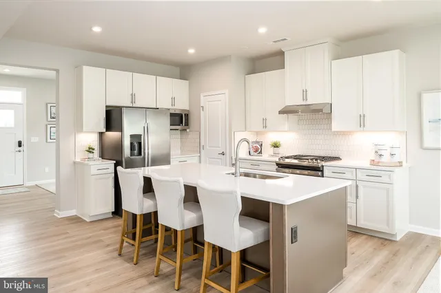 a kitchen with a dining table chairs refrigerator and cabinets