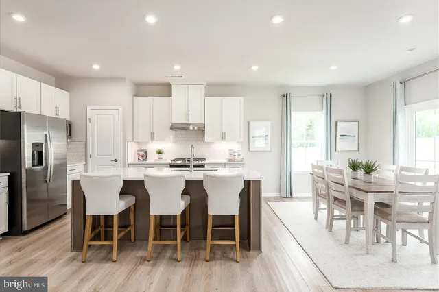 a large kitchen with kitchen island a dining table and chairs