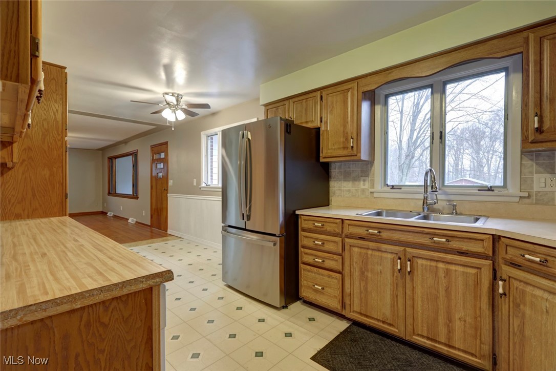 8104 Barnes Road Vermilion, OH 44089 - Photo 15 of 40 Kitchen featuring decorative backsplash, stainless steel refrigerator, ceiling fan, and sink