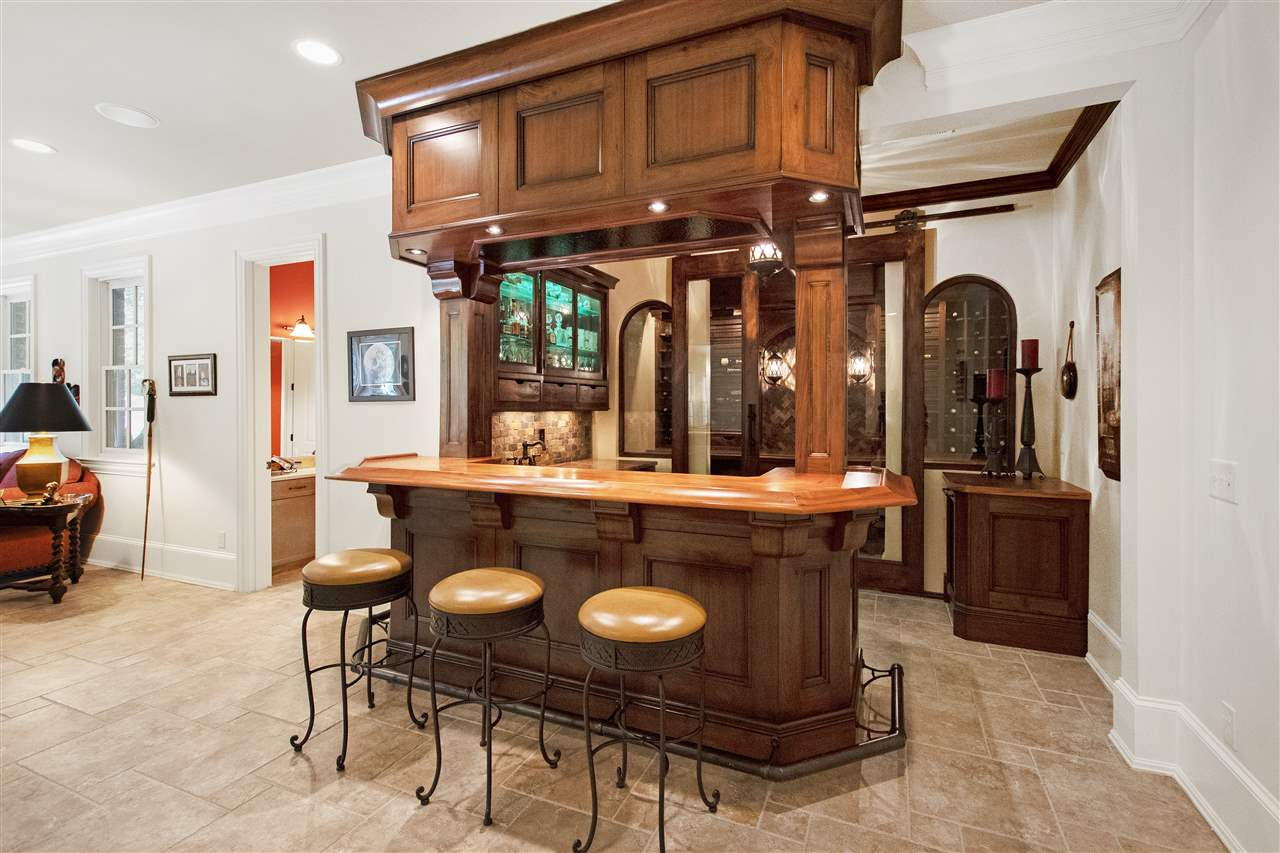 1512 Consett Court Raleigh, NC 27613 - Photo 19 of 30 Custom bar with tiger maple top and wine grotto with glass barn doors Bar and Wine Grotto