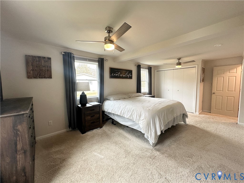 7406 Stubbs Bridge Road Spotsylvania, VA 22551 - Photo 11 of 13 a spacious bedroom with a bed and a chandelier