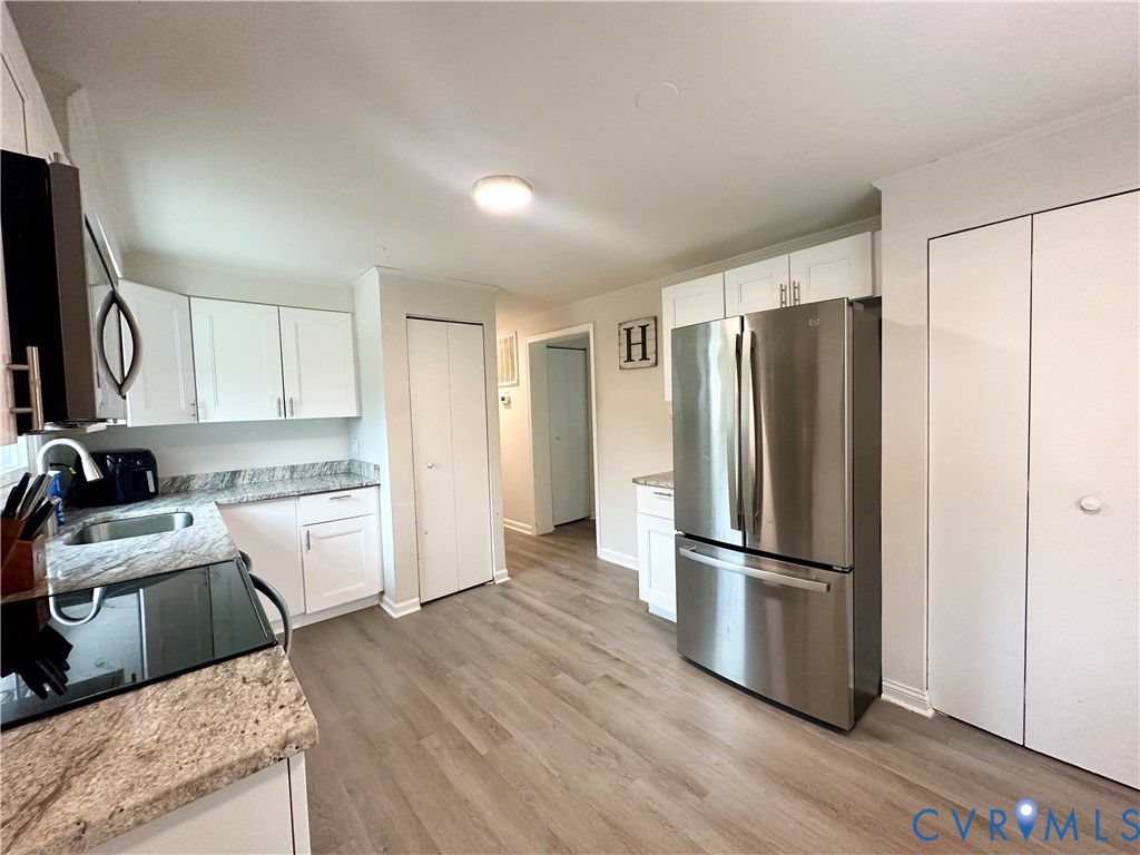 7406 Stubbs Bridge Road Spotsylvania, VA 22551 - Photo 8 of 13 a kitchen with a refrigerator a sink and a stove top oven