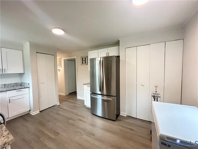 a kitchen with stainless steel appliances a refrigerator and wooden floor