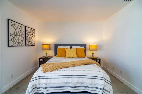 a bedroom with a bed and lamps