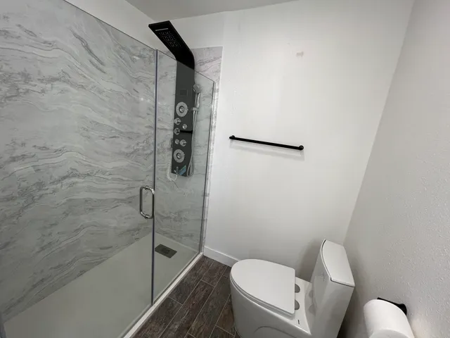a bathroom with a toilet and a shower