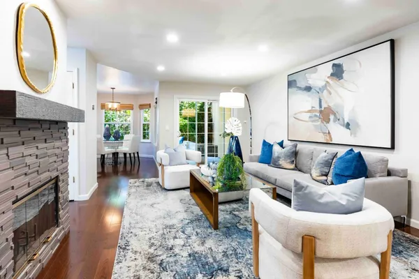 a living room with fireplace furniture and a large window