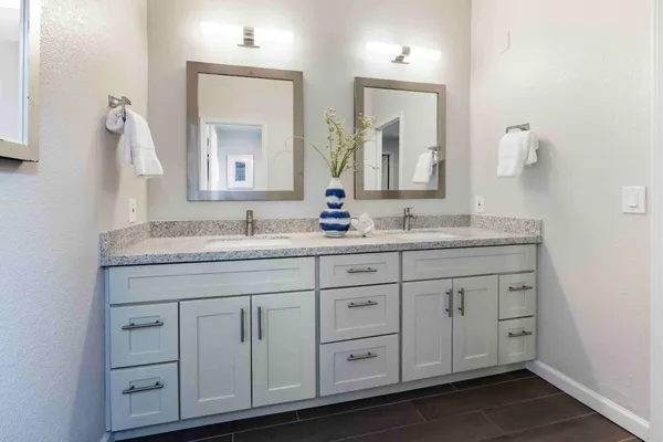 a bathroom with double sink and a mirror