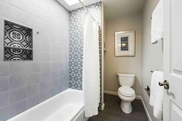 a white toilet sitting next to a white bath tub