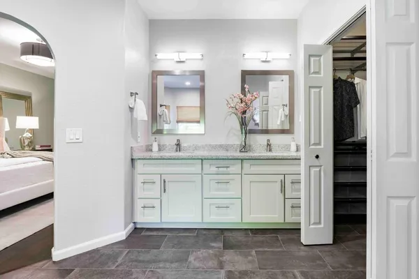 a spacious bathroom with a granite countertop sink and a mirror