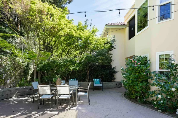 a view of backyard with outdoor seating and plants