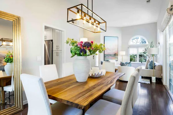 a view of a dining room with furniture a potted plant and wooden floor