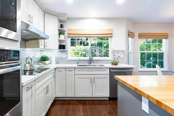 a kitchen with white cabinets and white appliances