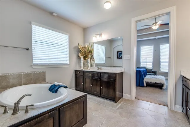 a spacious bathroom with a granite countertop sink and a mirror