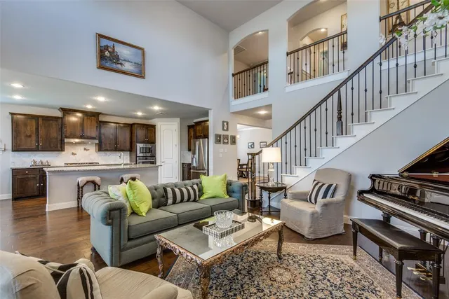 a living room with furniture kitchen view and a wooden floor