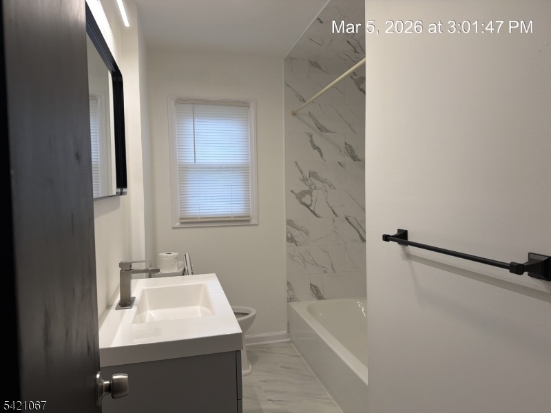 900 Smith Street, Unit 2 Linden, NJ 07036 - Photo 7 of 9 a bathroom with a sink a bathtub and a shower