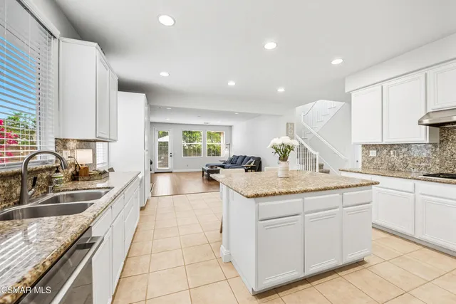 a large kitchen with granite countertop a sink and cabinets