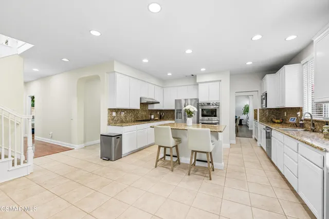 a kitchen with a sink and chairs