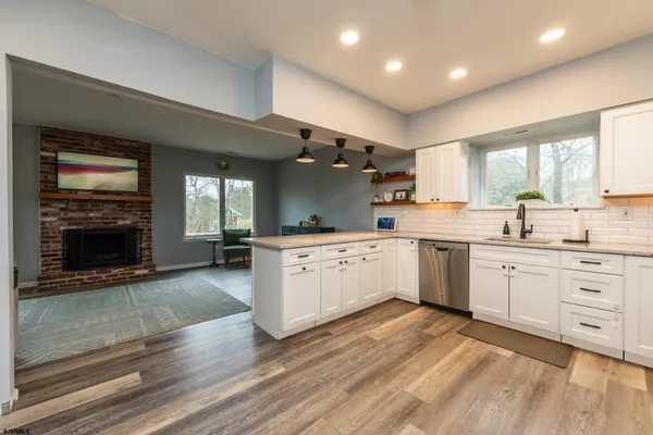 a living room with furniture a view of dining room and wooden floor