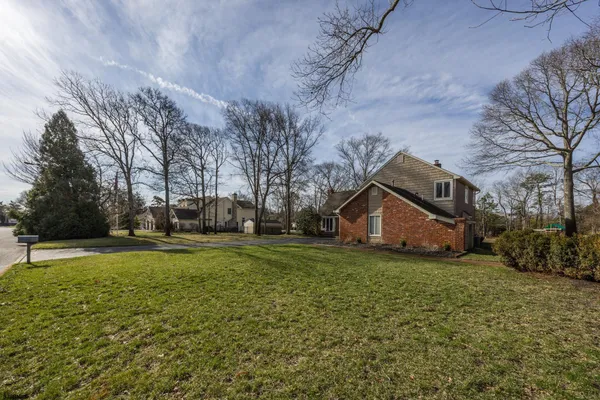 a backyard of a house with lots of green space and trampoline