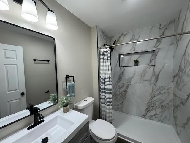 a bathroom with a sink toilet and shower