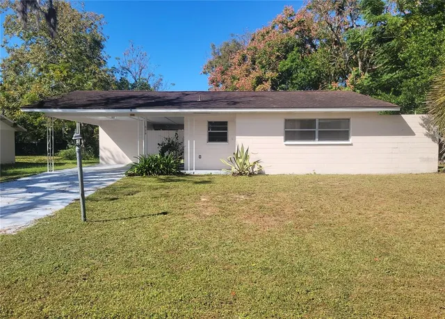a view of a house with backyard and trees