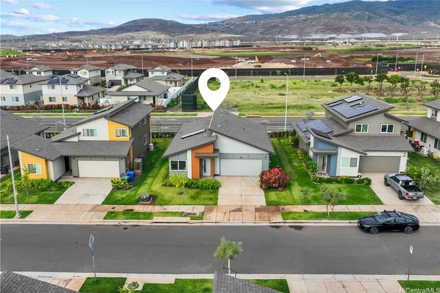an aerial view of residential houses with outdoor space and parking