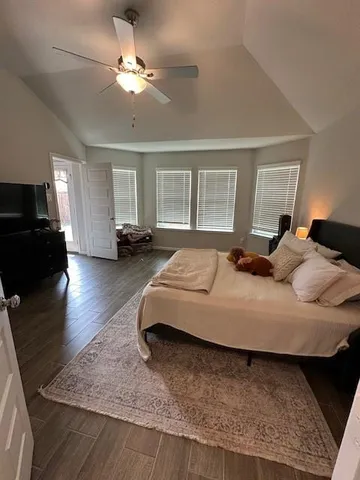 a bedroom with a bed couches and flat screen tv