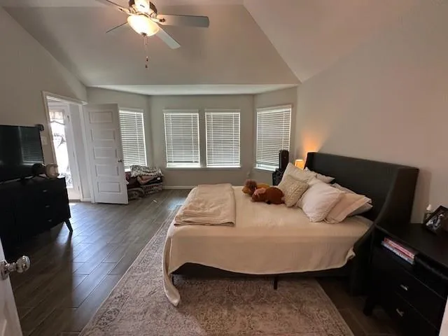 a bed sitting in a bedroom next to a window with tv and dresser