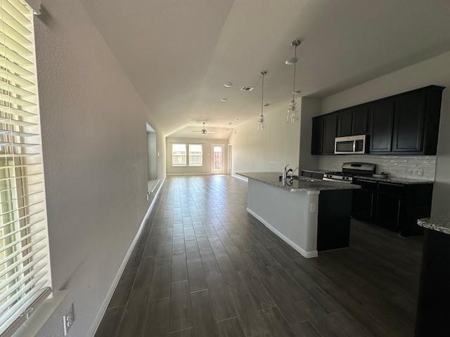 14032 Earlham Street Pilot Point, TX 76258 - Photo 32 of 32 a kitchen with granite countertop a stove top oven a sink and a microwave